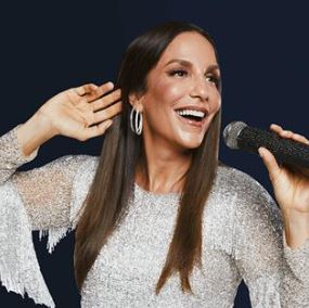 Imagem da cantora de axé Ivente Sangalo sorrindo e segurando um microfone