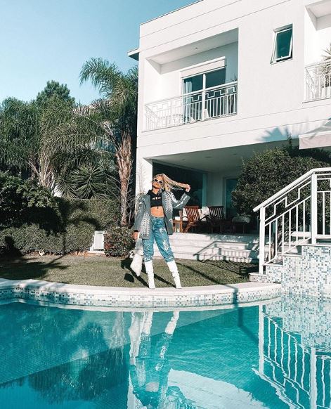 Na imagem, a cantora Luisa Sonza mostra parte de sua mansão nova, ela está à beira da piscina enquanto posa para a foto