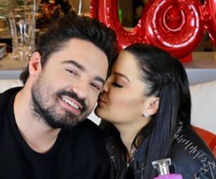 na foto a cantora maiara e o cantor fernando, eles são namorados há um ano. Na imagem ela está dandoum beijo no rosto do cantor e ele está sorrindo para a câmera