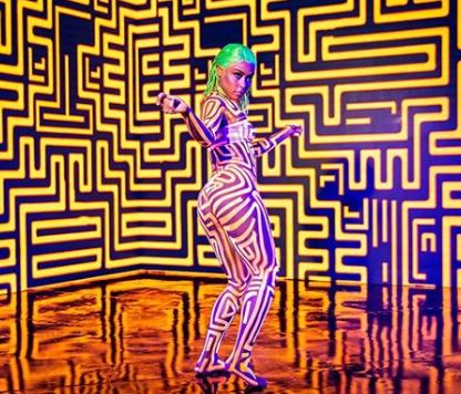 foto do clipe de MC Rebecca, na imagem ela está com tinta neon desenhada pelo corpo